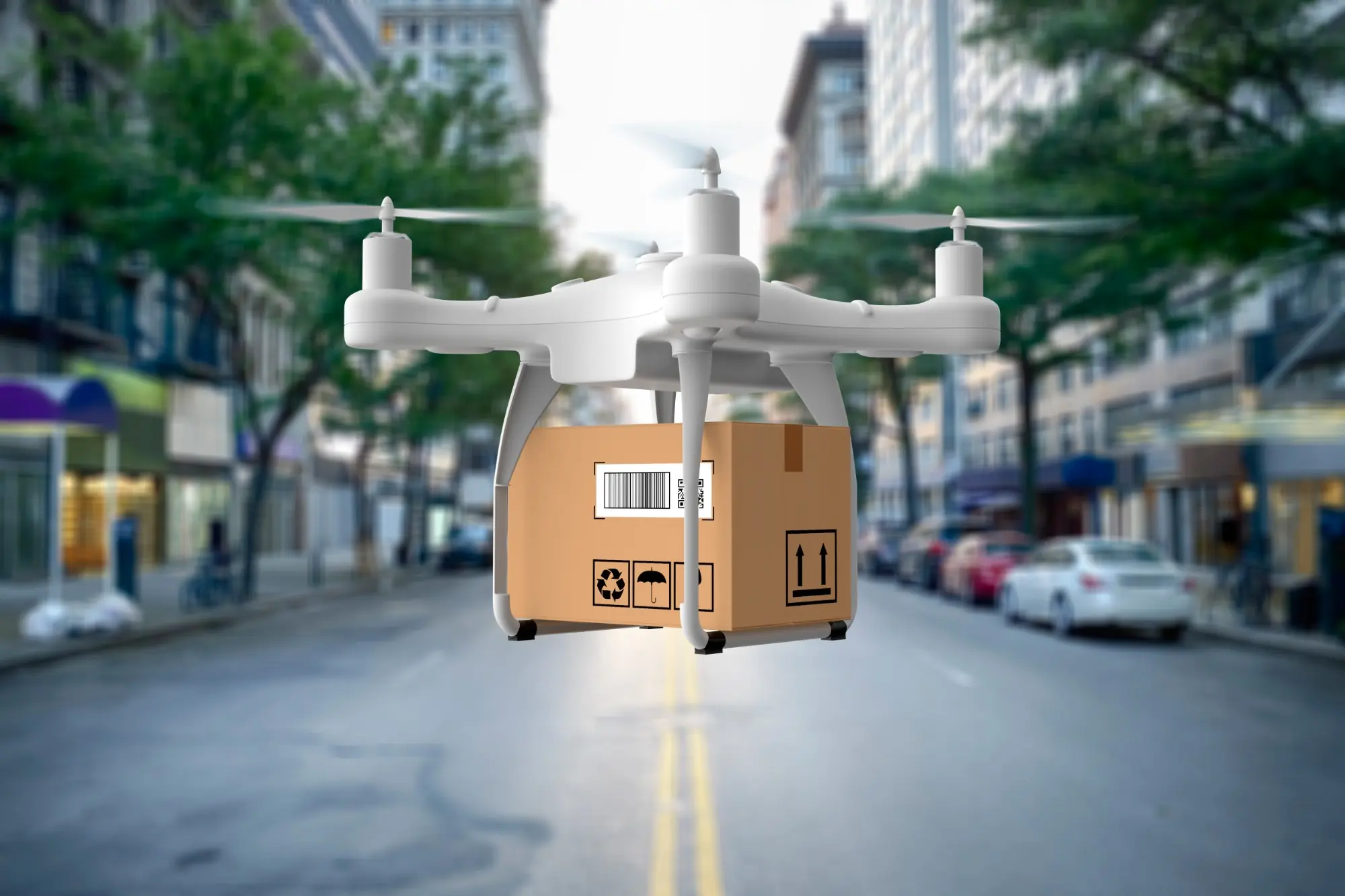 A delivery drone carrying a cardboard package above a city street